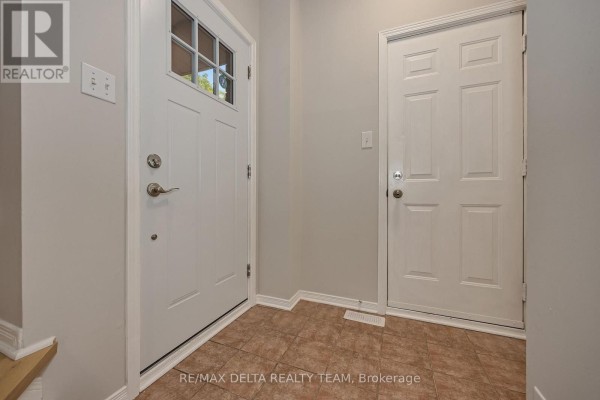 Interior view of an entryway with beige tiled floor and two white doors. - 858 Como Crescent, Ottawa