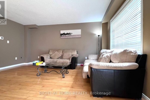 Living room with sofas, coffee table, and hardwood floors, wide angle shot. - 858 Whetherfield Street, London North