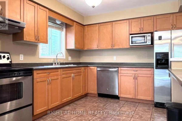 Kitchen with light wood cabinets, stainless steel appliances, and tile flooring. - 858 Whetherfield Street, London North