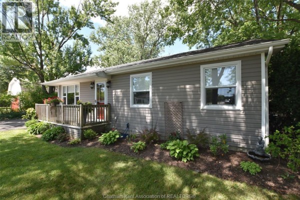 Side view of the house showing beige vinyl siding and white-trimmed windows. - 8585 James Street, Charing Cross