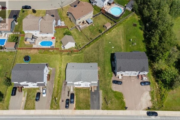 Aerial view of townhouses and single-family homes with swimming pools. - 859 Ryan Street, Moncton