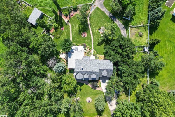 Aerial view of a large house with a grey roof, surrounded by trees and gardens. - #86 52514 Rge Road 223, Rural Strathcona County