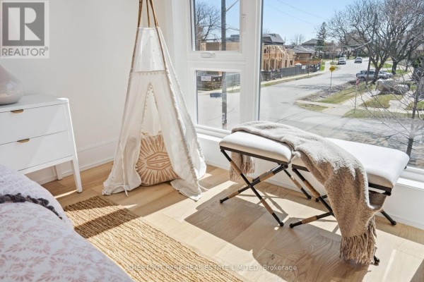 Hallway with hardwood floors, glass railing, and modern art - 86 Edgecroft Road Toronto