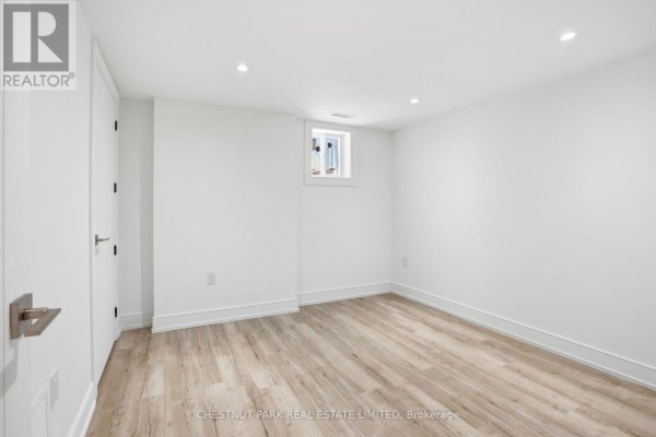 Modern kitchen with gas stovetop, marble backsplash, and wooden range hood - 86 Edgecroft Road Toronto