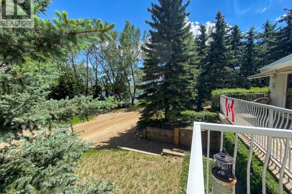 View from deck of tree-lined driveway and lake through the trees. - 86 Ferguson Bay, Webb Rm No  138