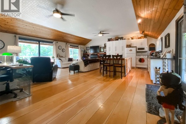 Spacious living area with wood floors, vaulted ceiling, sofas, and an open kitchen. - 86 Ferguson Bay, Webb Rm No  138