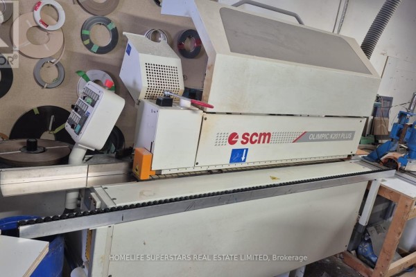 An SCM Olimpic K201 Plus edge banding machine with a white casing and black conveyor belt. - Unit 9 - 86 Melford Drive, Toronto