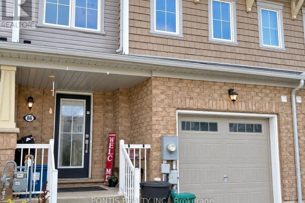 Close-up of the front entrance with a black door, beige garage, and brick exterior. - 86 Munro Circle, Brantford