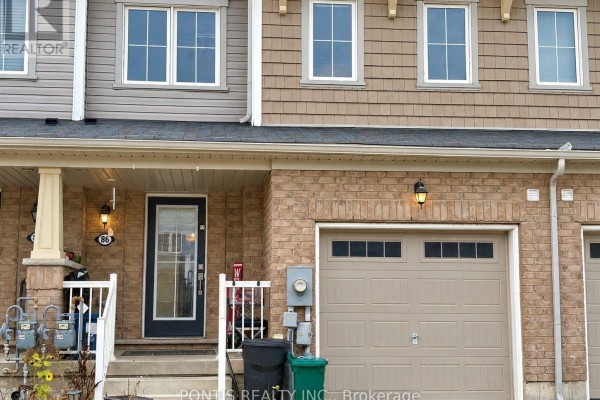 View of townhouse entrances, garages, and brick and siding exterior. - 86 Munro Circle, Brantford
