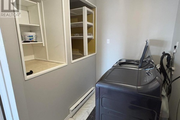 Bedroom with dark gray walls, wood laminate flooring, and a mirrored closet. - 86 N Main Street, Glovertown