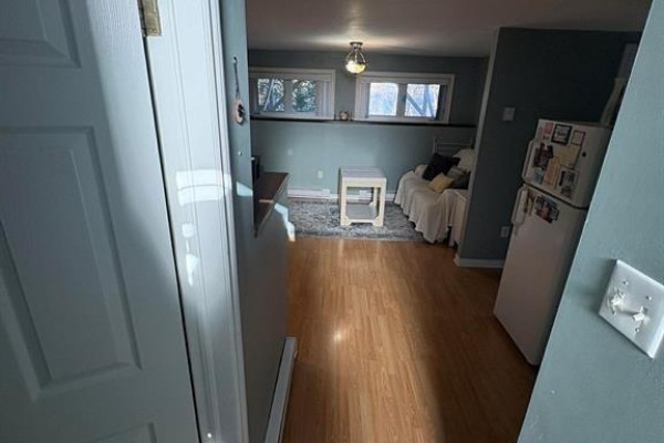 Bedroom with dark gray walls, white trim, a window, and a white electric baseboard heater. - 86 N Main Street, Glovertown