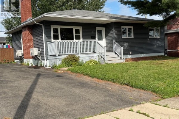 Front view of the grey bungalow at 86 Poirier Drive, showing the porch and driveway. - 86 Poirier Drive, Moncton