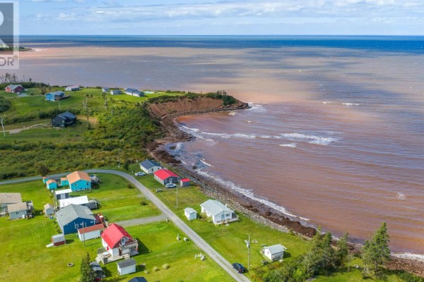 Aerial view of houses along the coast with red-brown water and a cliffside. - 86 Red Cliff Drive, Seafoam