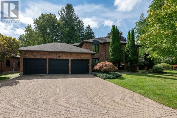 Wide view of a brick home with a three-car garage and a paved driveway. - 86 Tobin Court, London South