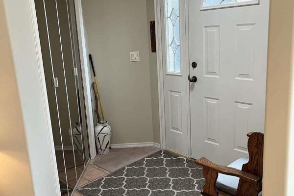 Interior view of the townhouse entrance with white doors and patterned rugs. - 860 Lanfranco Road Unit# 11, Kelowna