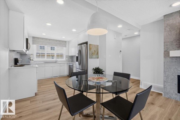 Kitchen and dining area with a glass table and four black chairs. - 862 Daniels Wy Sw, Edmonton