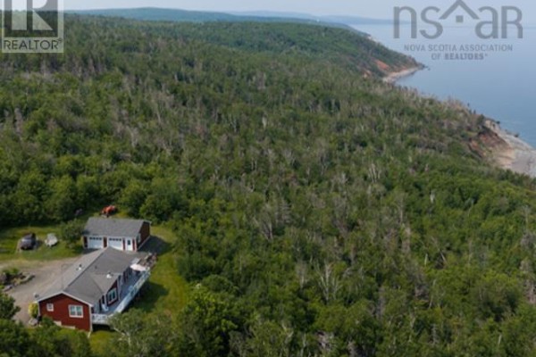 Expansive aerial view of the property showing the red house, garage, and surrounding coastal forest. - 8646 Highway 337 Georgeville   B2g 2l1, Morar