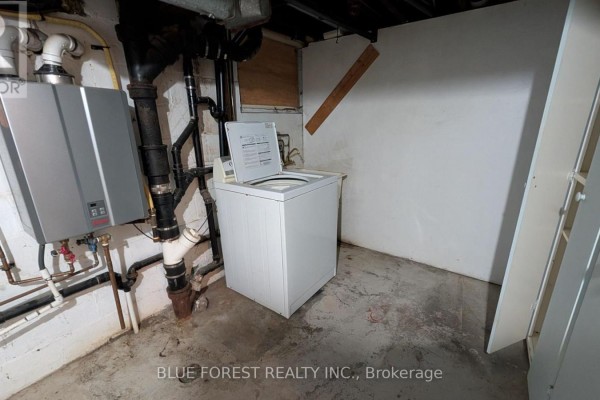 Basement laundry with water heater, washing machine, and cabinets - 867 Queens Avenue London East