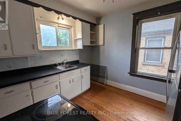 Kitchen with white cabinets and black countertops - 867 Queens Avenue London East