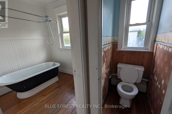 Clawfoot tub and toilet in bathroom - 867 Queens Avenue London East