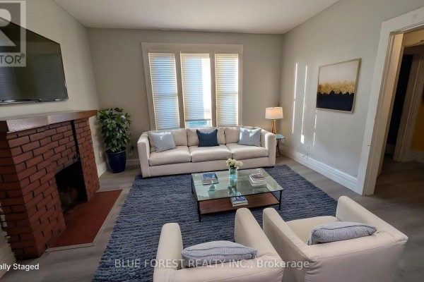 Living room with brick fireplace, sofa, armchairs, and coffee table - 867 Queens Avenue London East