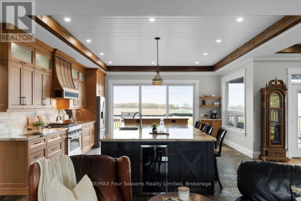 Modern kitchen with island, wine fridge, and field view - 8672 County Rd 91 Road Clearview