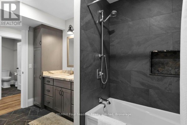 Modern bathroom with bathtub, shower, vanity, and toilet - 8672 County Rd 91 Road Clearview