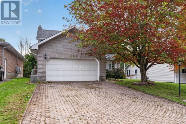 Paved driveway leading to a white garage door on a light-colored brick house. - 868 Laflin Street, Cornwall