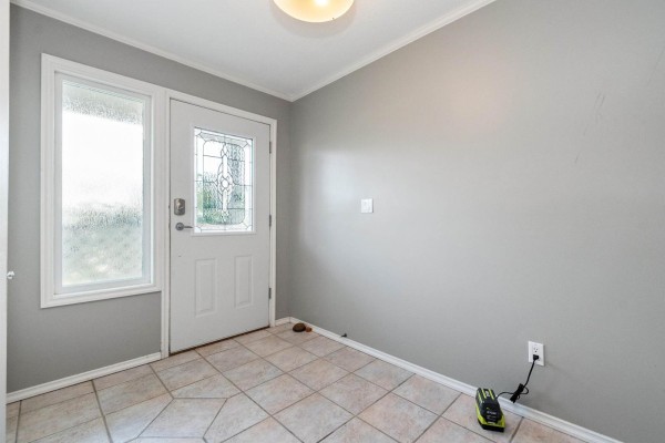 Kitchen with wood cabinets, dark countertops, white stove, and mosaic tile backsplash. - 8683 Tilston Street, Chilliwack Proper South, Chilliwack
