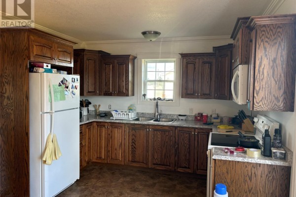 Kitchen with dark oak cabinets, a white refrigerator, stainless steel sink, and a white stove. - 86a Main Road, Piccadilly