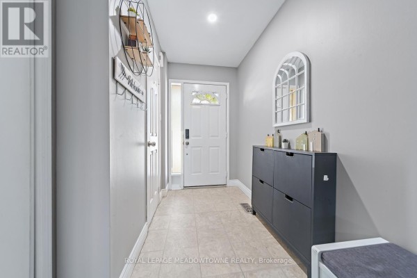 Interior entryway with beige tile floor, grey walls, and a white front door. - 87 - 200 Cresthaven Road, Brampton
