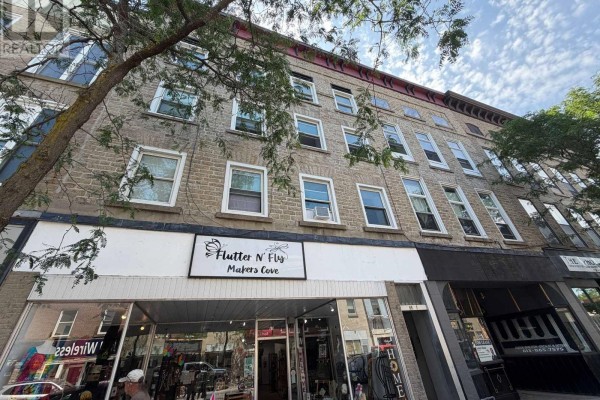 Exterior facade of a multi-story brick building with multiple windows and awnings. - 87-93 King Street W, Brockville