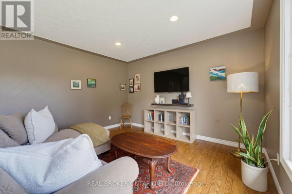 Living room featuring a sectional sofa, coffee table, and hardwood floors with natural light. - 87 Ball Street, Brant