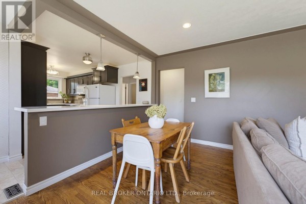 Dining area with a wooden table and chairs, open to a dark-cabinet kitchen. - 87 Ball Street, Brant
