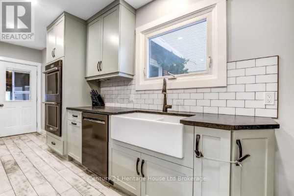Modern kitchen with gray cabinets, large island, and stainless steel appliances - 87 Bay Street, Woodstock