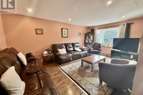 Living room featuring leather sofas, wooden coffee table, and large window - 87 Lincoln Cross, Halifax