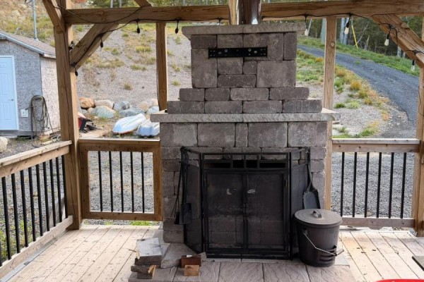 Outdoor covered patio with a large stone fireplace and seating area. - 87 Maplesue Point Drive, Molega Mines