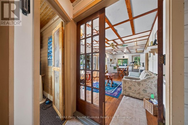 Living room with floral sofa, blue rug, dining table & kitchen - 87 Millies Road Seguin