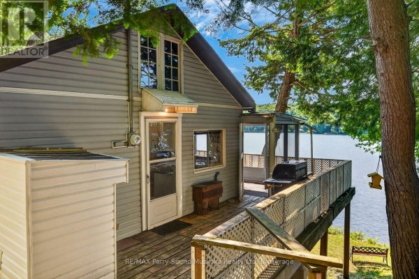 Deck with grill and screened porch overlooking a lake - 87 Millies Road Seguin