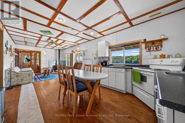 Kitchen with wood paneled ceiling, dining set, and lake view - 87 Millies Road Seguin