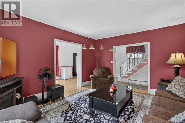 Living room showing furniture, doorways to other rooms, and a staircase. - 87 Milner Road, Moncton