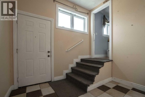Empty bedroom with light pink walls, wood-look laminate flooring, and dark grey curtains. - 872068 Range Road 235, Rural Northern Lights, County Of