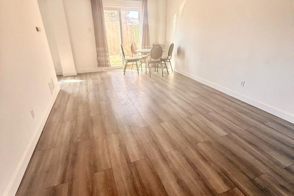 View of an empty dining area with a table and chairs, light wood flooring, and patio doors. - 873 Southdale Road E, London South