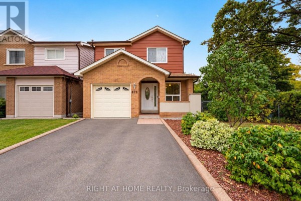 View of the front entrance of a residential house with a brick facade and white garage door. - 875 Messenger Meadow Drive, Mississauga