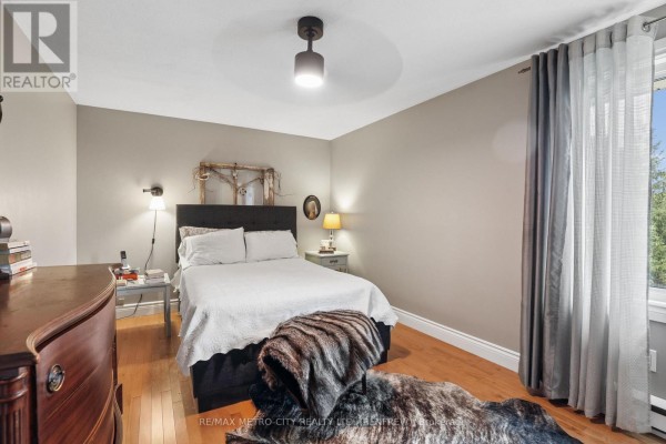 Bedroom with queen bed, dresser, and window with curtains - 876 Hillsview Street Renfrew