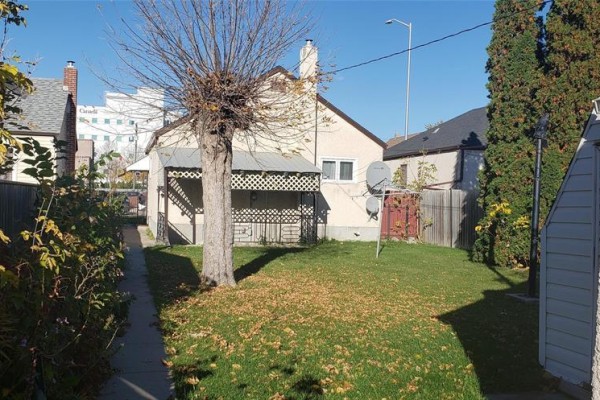 Living room with red carpet, sofa, decorative fireplace, television, and archways to other rooms. - 876 William Avenue, Winnipeg