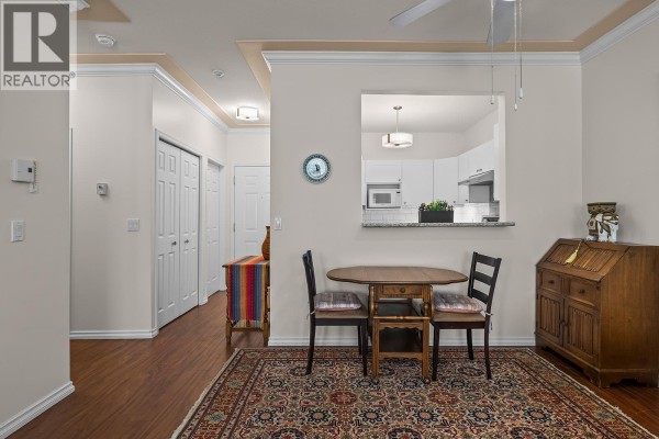 View from dining area towards hallway and kitchen, with living room in background. - 877 Klo Road Unit# 112, Kelowna
