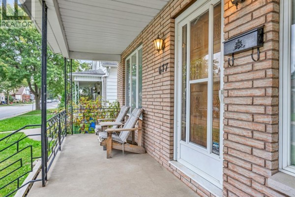 Front porch of 877 Pierre Avenue with two chairs and brick exterior. - 877 Pierre Avenue, Windsor