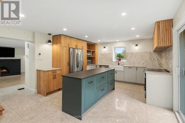 Modern kitchen with a large island, stainless steel appliances, and light tile flooring. - 877 St Felix Road, Clarence Rockland