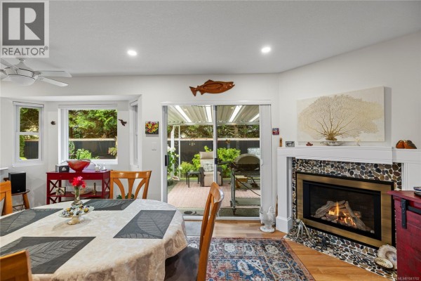 Dining area with a table setting and sliding doors opening to a covered patio. - 879 Aberdeen Dr, Parksville